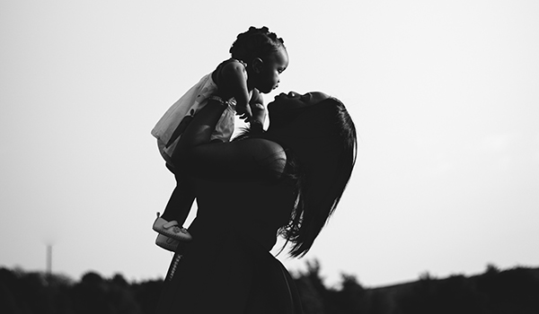 Mother Lifting Child Up To Sky