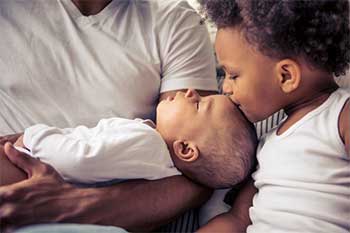 Father holding Baby with Daughter
