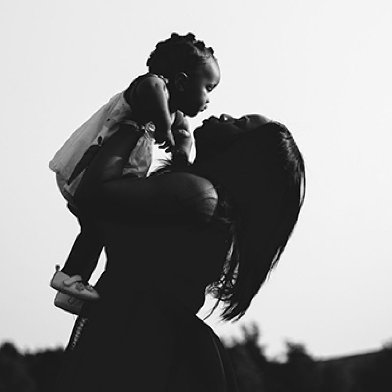 Mother Lifting Child Up To Sky